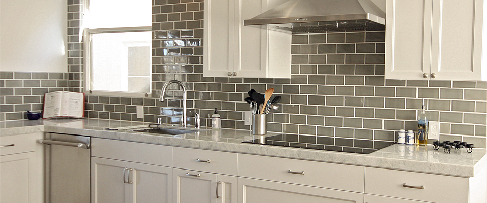 Classic traditional kitchen with “Princess White” quartzite stone slab, handcrafted grey tiles, custom white cabinetry, glass cooktop.