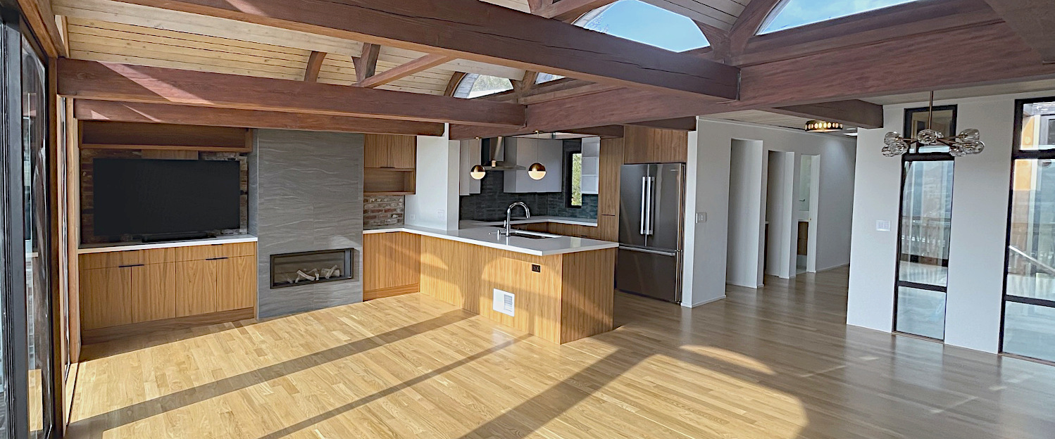 Midcentury modern great room with barrel vault roof, hand-glazed backsplash tiles, exposed brick.
